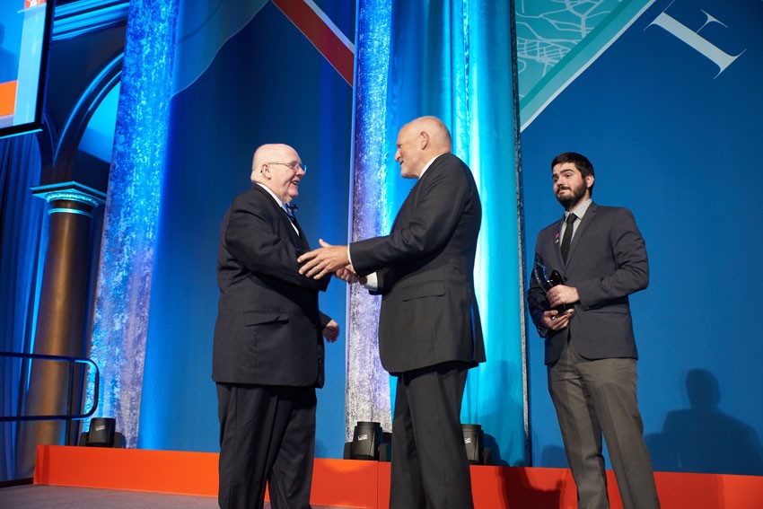 Dr. John Stack receives the Higher Education Impact Award on behalf of Florida International University from Dr. Leo Lambert, Board of Trustees. Dr. John Stack receives the Higher Education Impact Award on behalf of Florida International University.